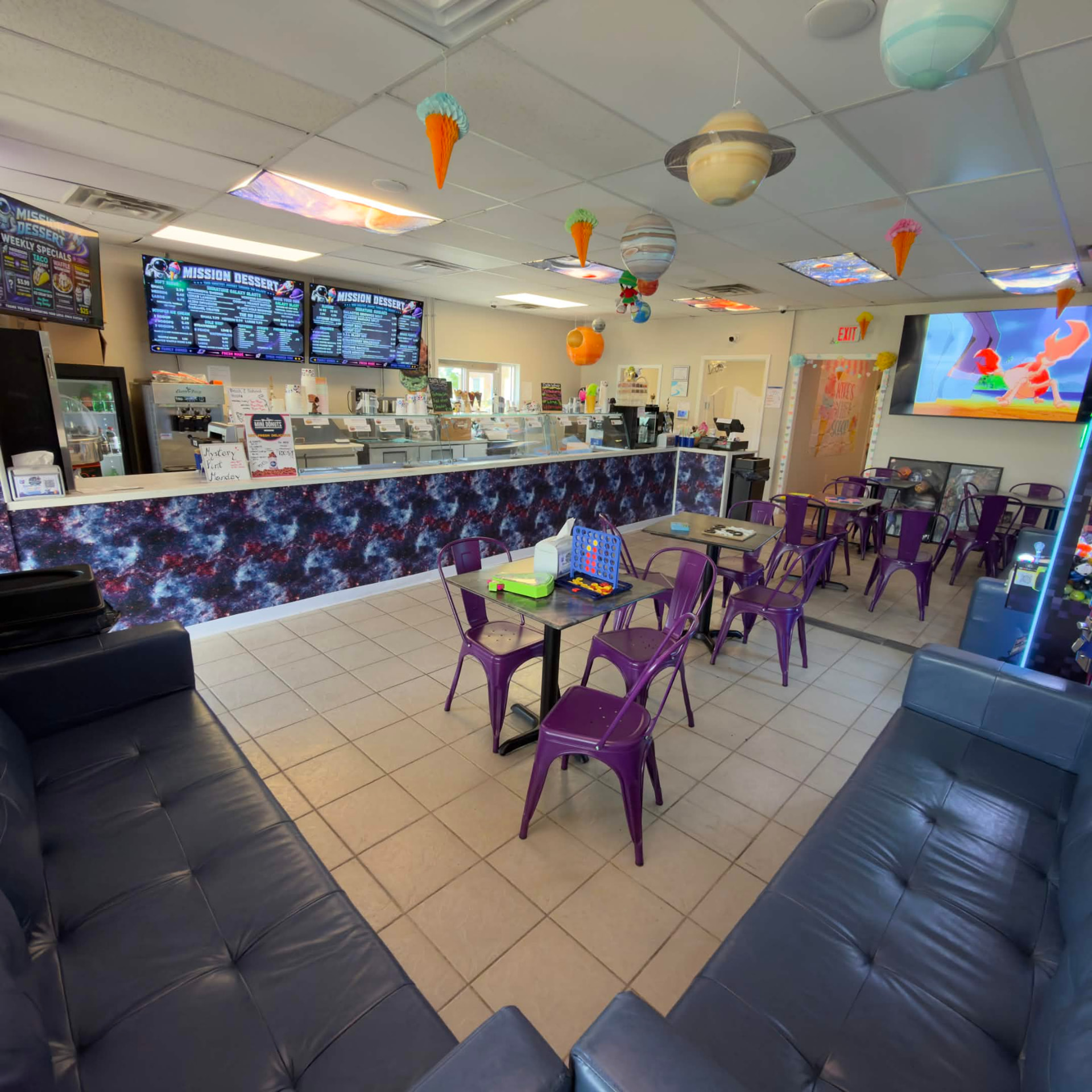 Inside the Mission Dessert parlor, with space-themed decor and purple seating